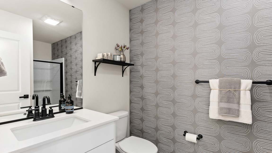 First floor private ¾ bathroom features step-in shower with glass door and modern black hardware