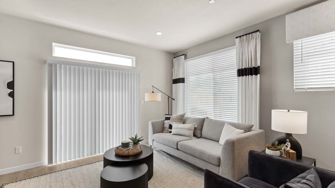 Model home living room with window above the glass slider door and additional natural light supplied by two windows