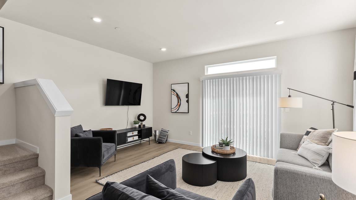 Living room featured in model home at Cathcart Crossing with window above the sliding glass door