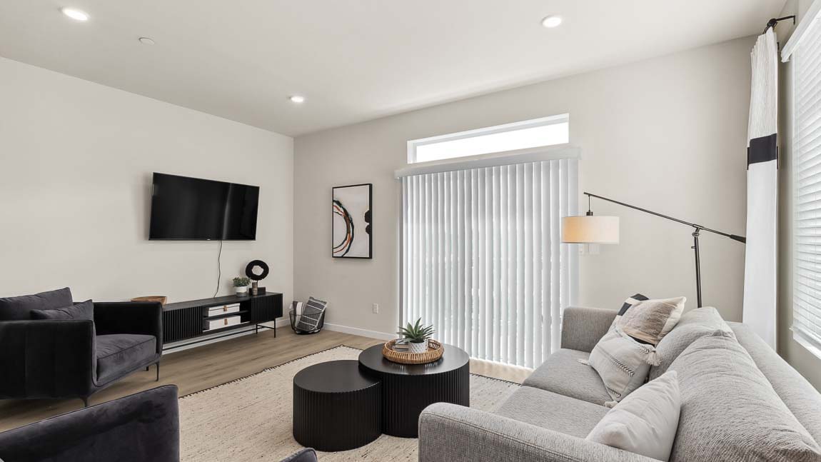 This Addison model home living room features a sliding glass door with window above