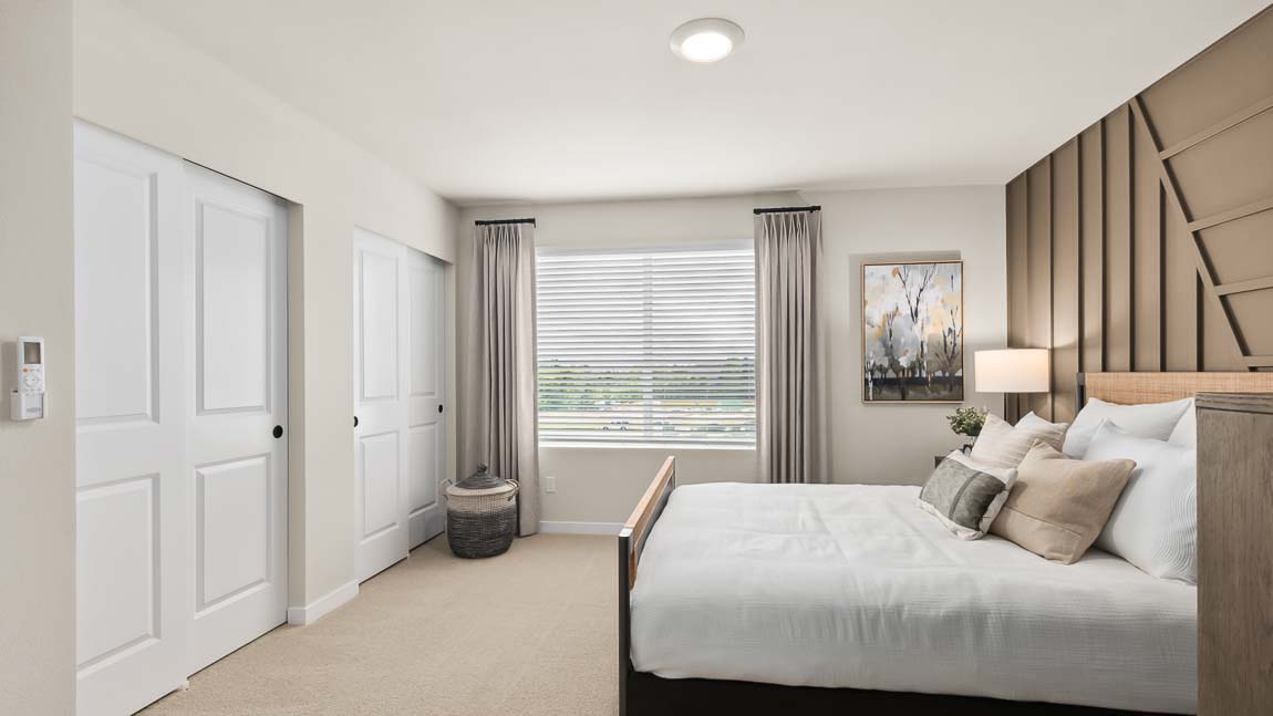 Alternate view of Bennett model home private bedroom suite that includes two double-slider door closets and a bright window for natural light