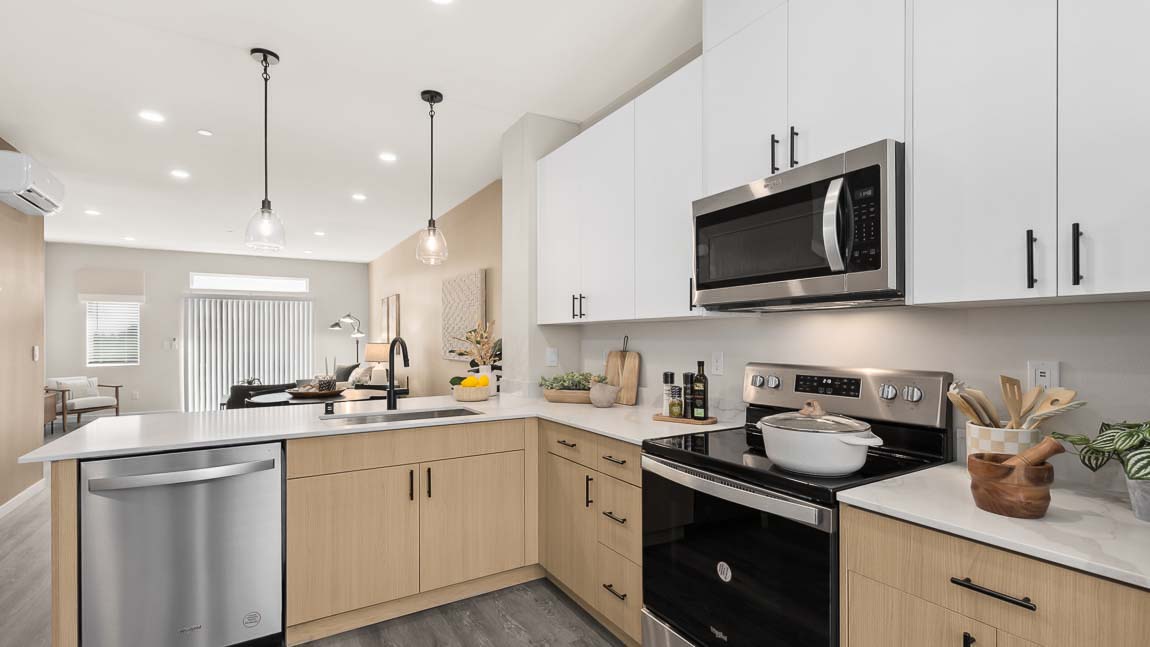 Closer view of Bennett model home kitchen with dual-color cabinets, quartz countertops, and convenient peninsula