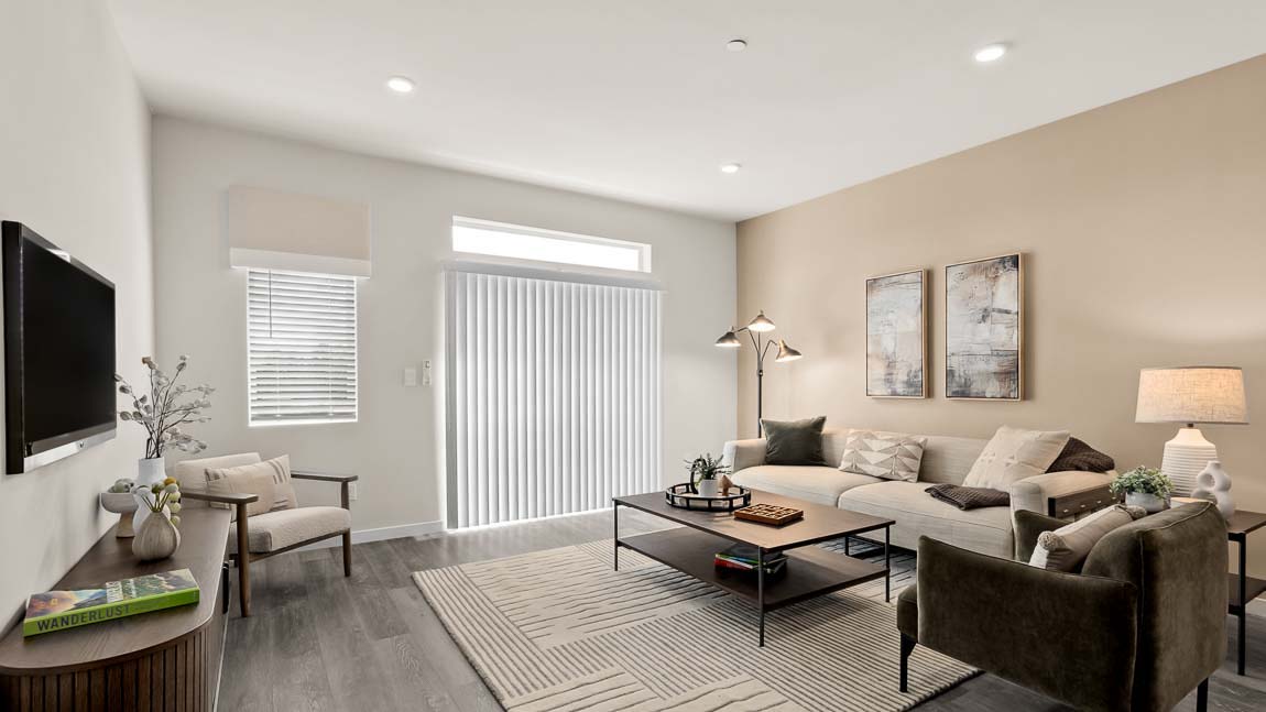 Bennett model living room with bright windows and slider door access to balcony