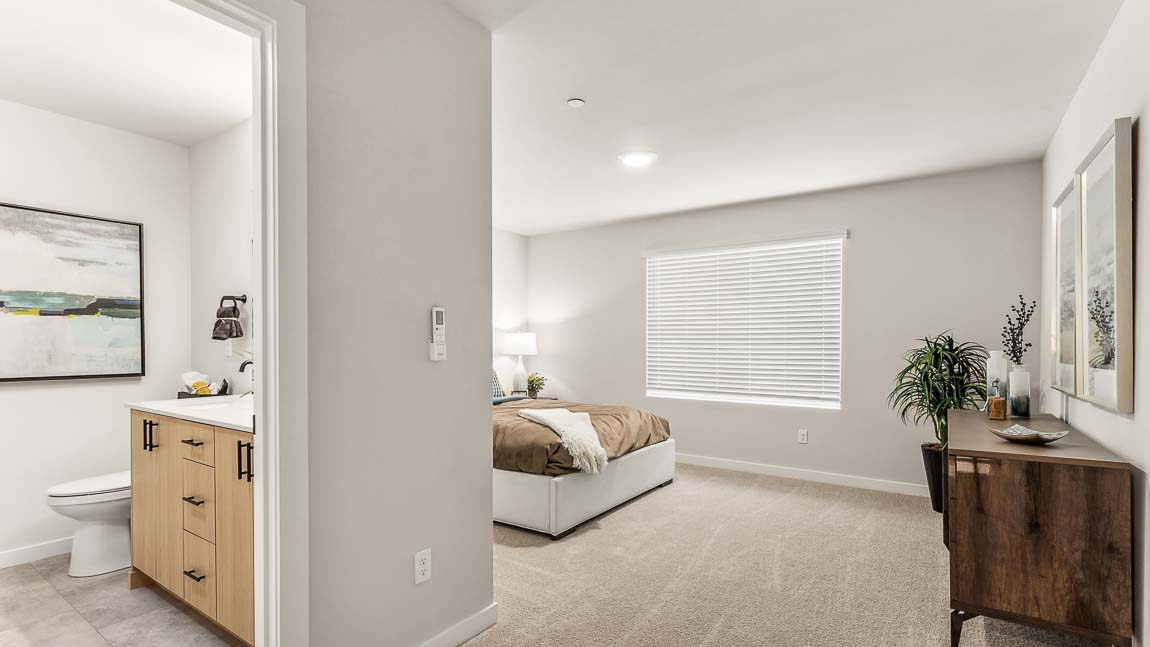 Entry into the private bedroom suite for Capri model home at Cathcart Crossing featuring private bathroom and large window in the bedroom