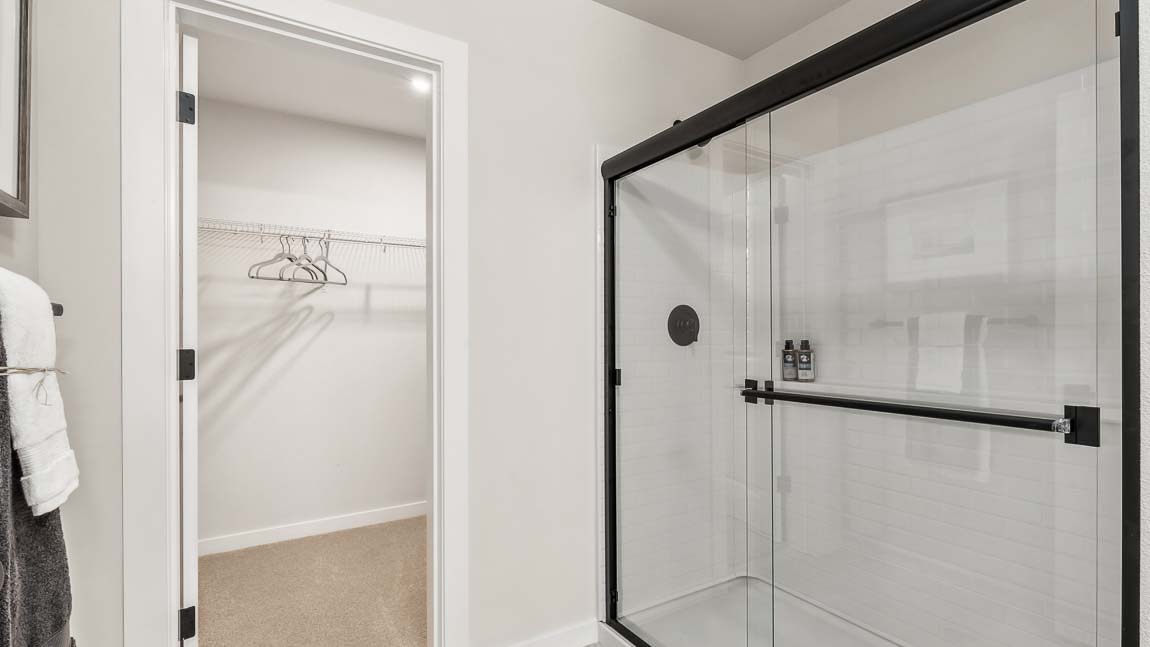 Capri floor plan private bedroom suite includes a private bath with quartz-countertop double-sink vanity and step-in shower