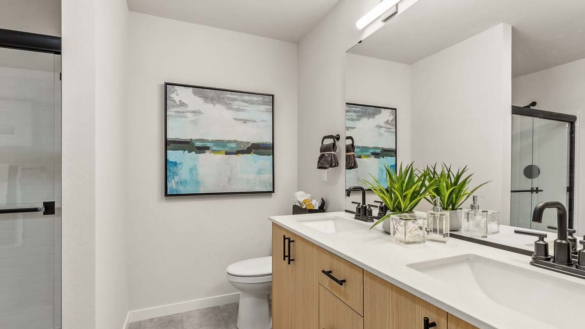 Capri floor plan private bedroom suite includes a private bath with quartz-countertop double-sink vanity and step-in shower