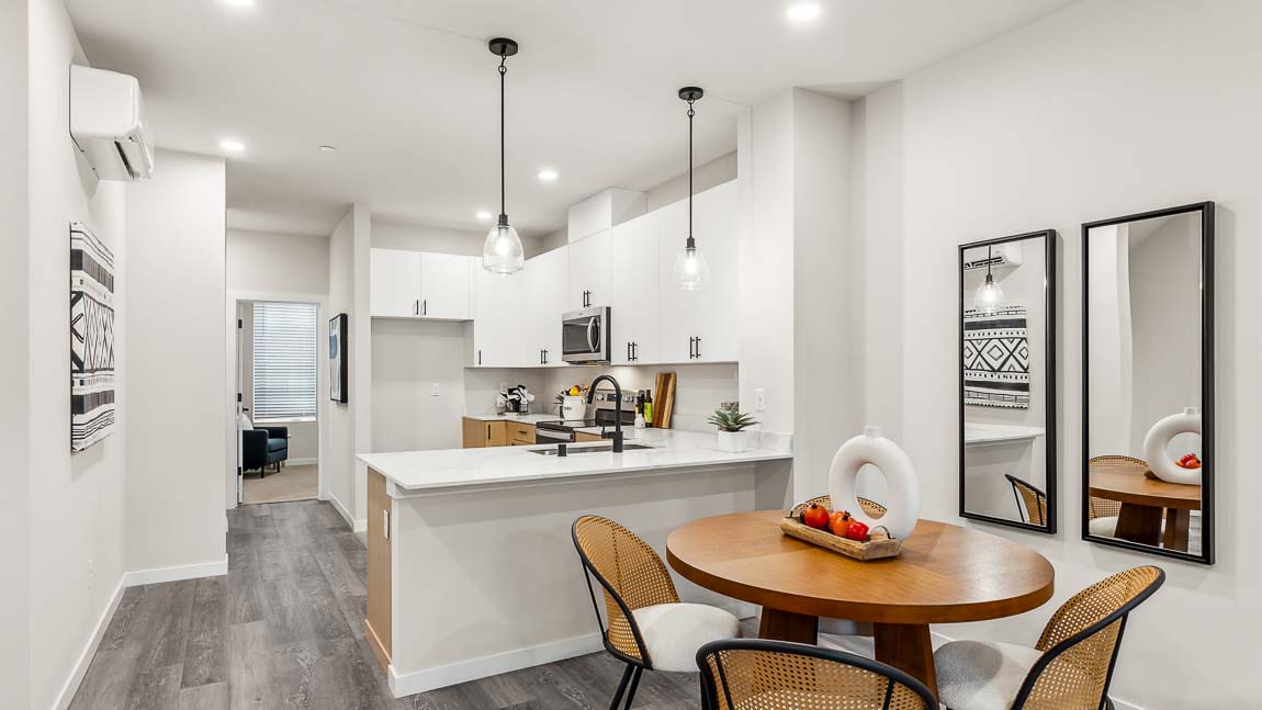 Capri model home dining room with nearby kitchen peninsula featuring undermount kitchen sink and pendant lighting