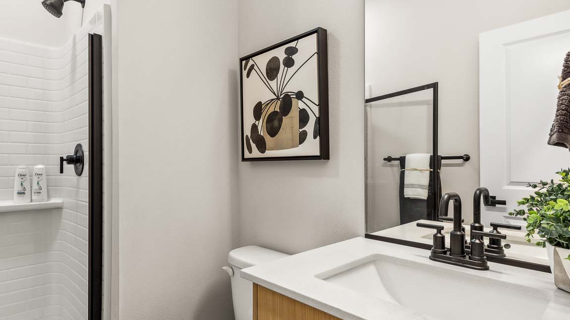 Capri model main floor three-quarter bathroom featuring quartz countertop vanity with undermount sink and step-in shower