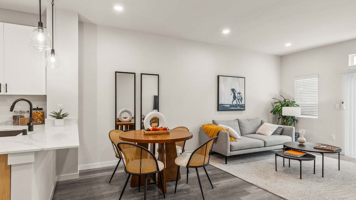 Capri model home living and dining rooms with bright corner window and nearby kitchen peninsula