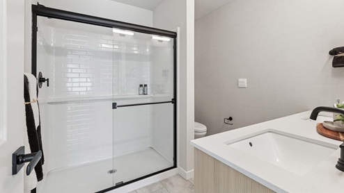 Closer view of the Bennett private upstairs bathroom step-in shower with glass sliding doors and built-in shelf