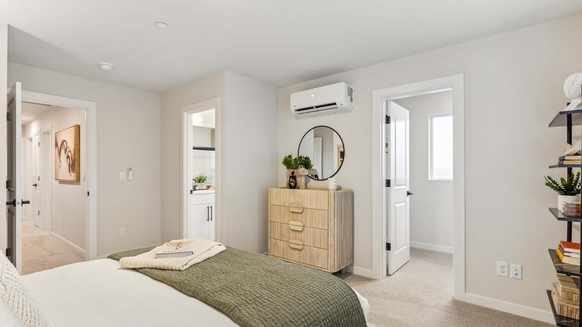 Primary bedroom with large window walk-in closet and large en suite private bathroom