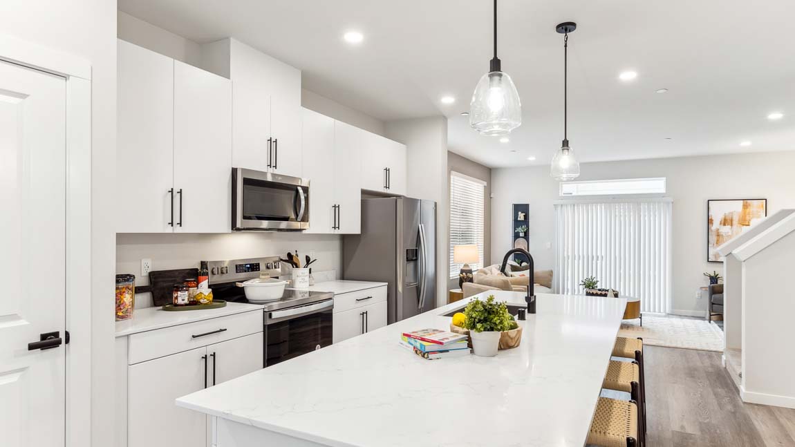 Large kitchen with quartz countertops stainless steel appliances and modern ﬁxtures