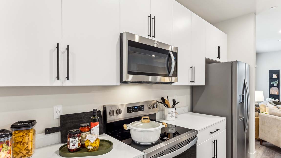 White cabinetry with stainless steel appliances in gourmet kitchen
