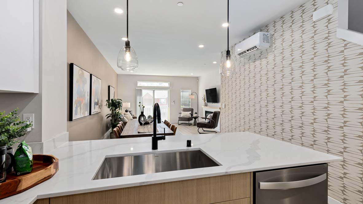 Closer view of Bennett model home kitchen with dual-color cabinets, quartz countertops, and convenient peninsula