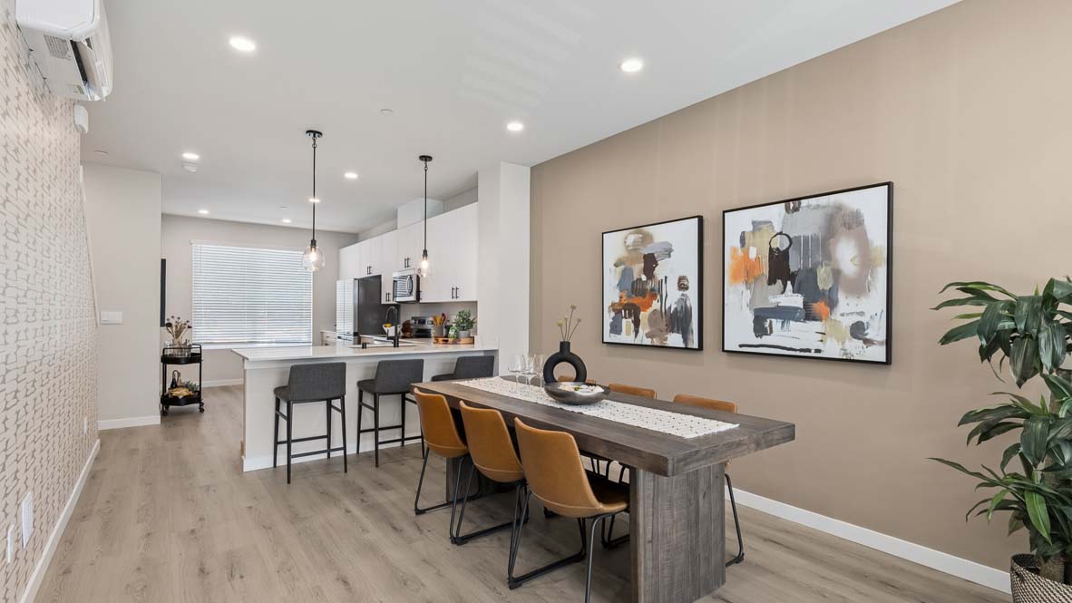 View of expansive kitchen peninsula with pendant lighting, dual-color cabinetry, and stainless-steel appliances in Bennett model home