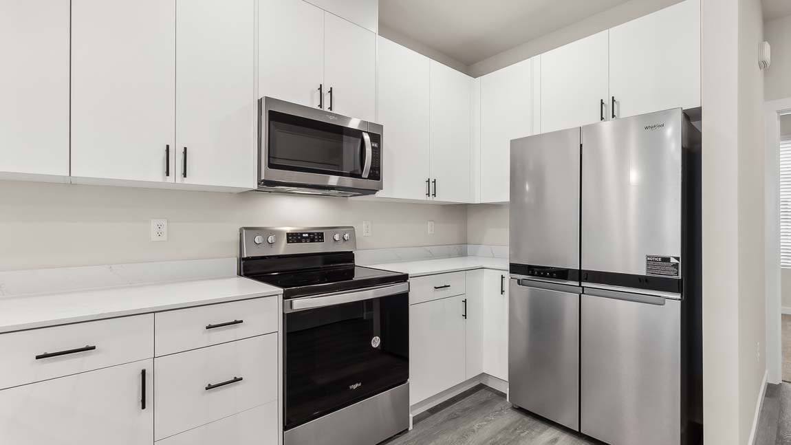 Stainless steel appliances and white cabinetry in kitchen