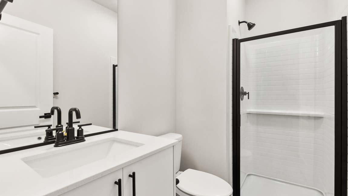 Walk-in shower quartz countertops and white cabinetry in Bath 3 on main floor