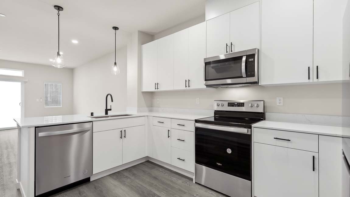 Large kitchen with stainless steel appliances and hardwood flooring