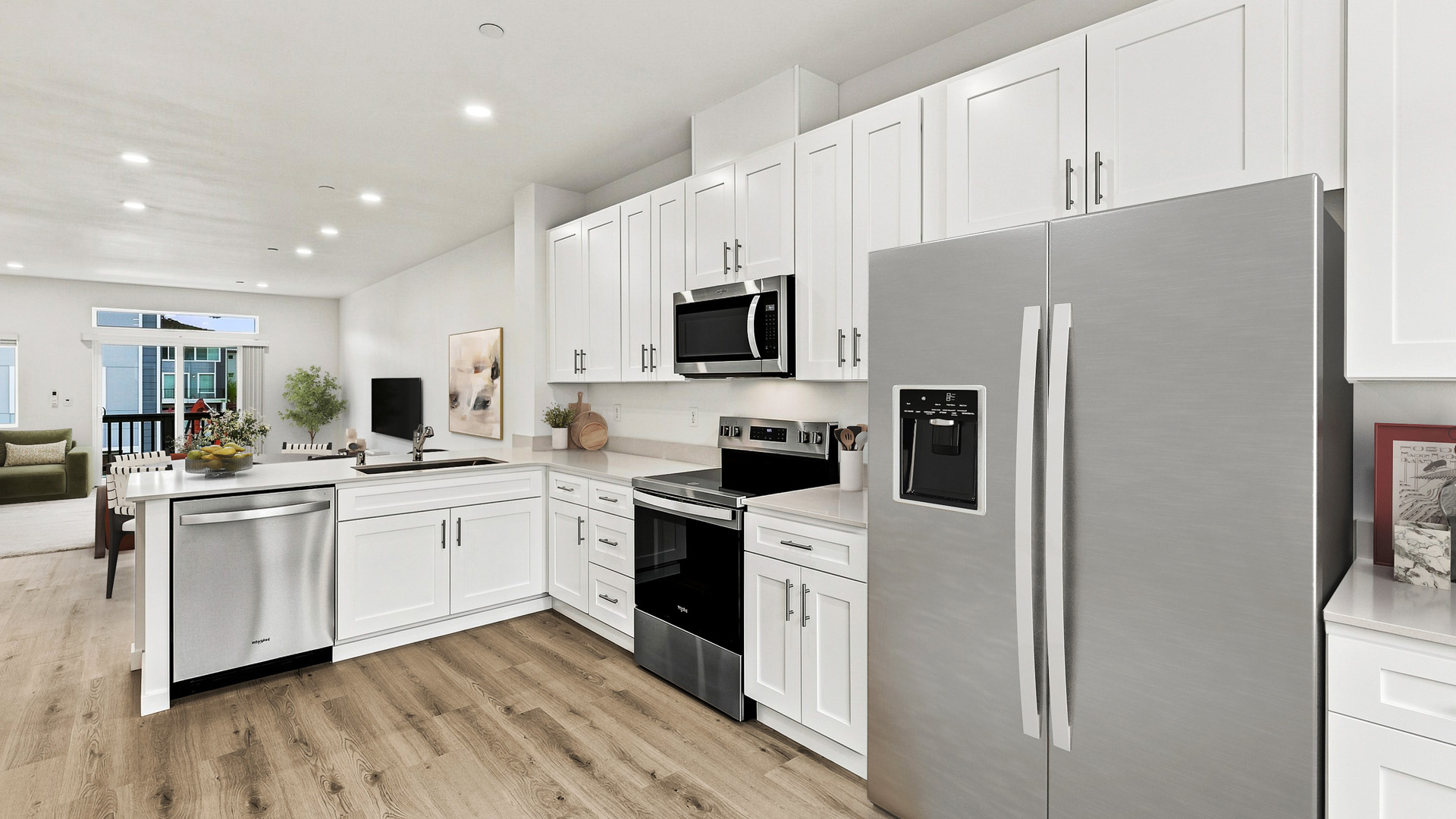 Bright modern kitchen with white shaker cabinets, stainless steel appliances, quartz countertops, and an open-concept layout leading to the living area.