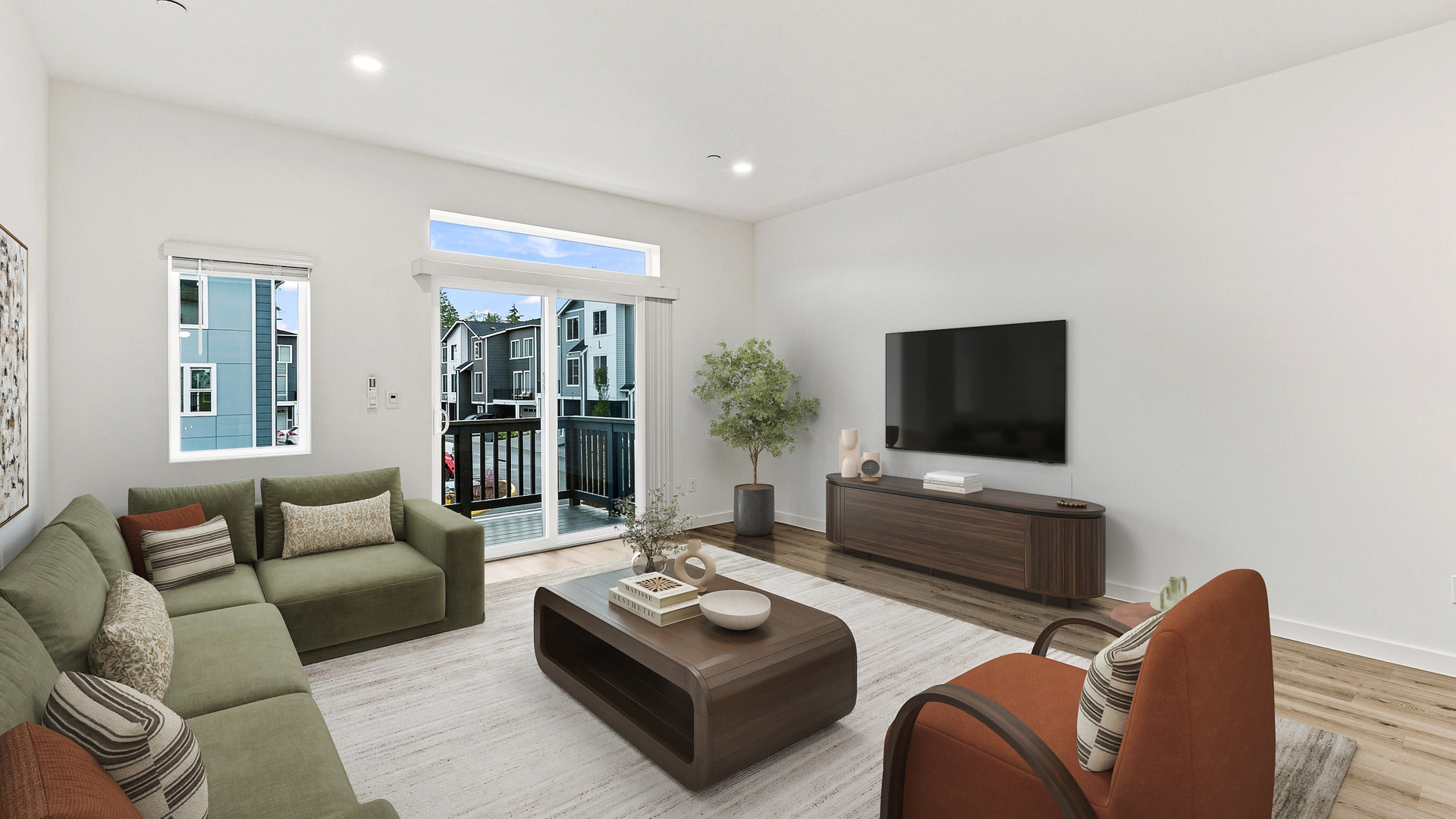 Spacious living room with sectional seating, accent chair, large wall-mounted television, and natural light from balcony doors and windows.