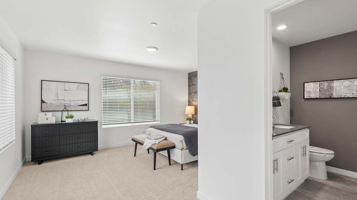Spacious primary suite with adjoining bathroom vanity, large bedroom area, and neutral finishes throughout.