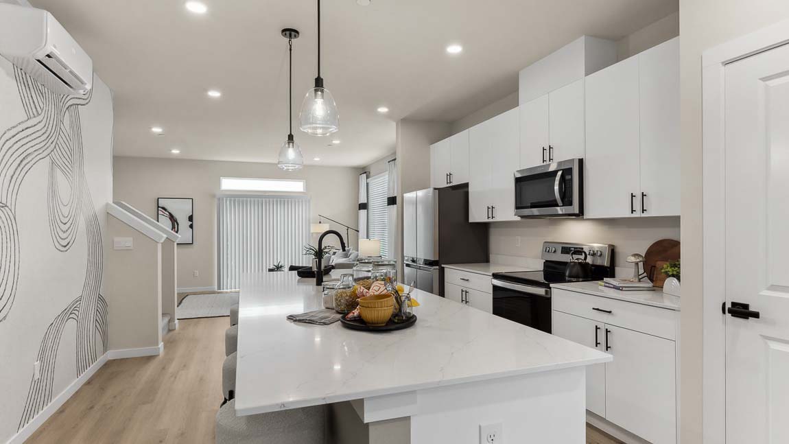 Large kitchen island with quartz countertops and white cabinets