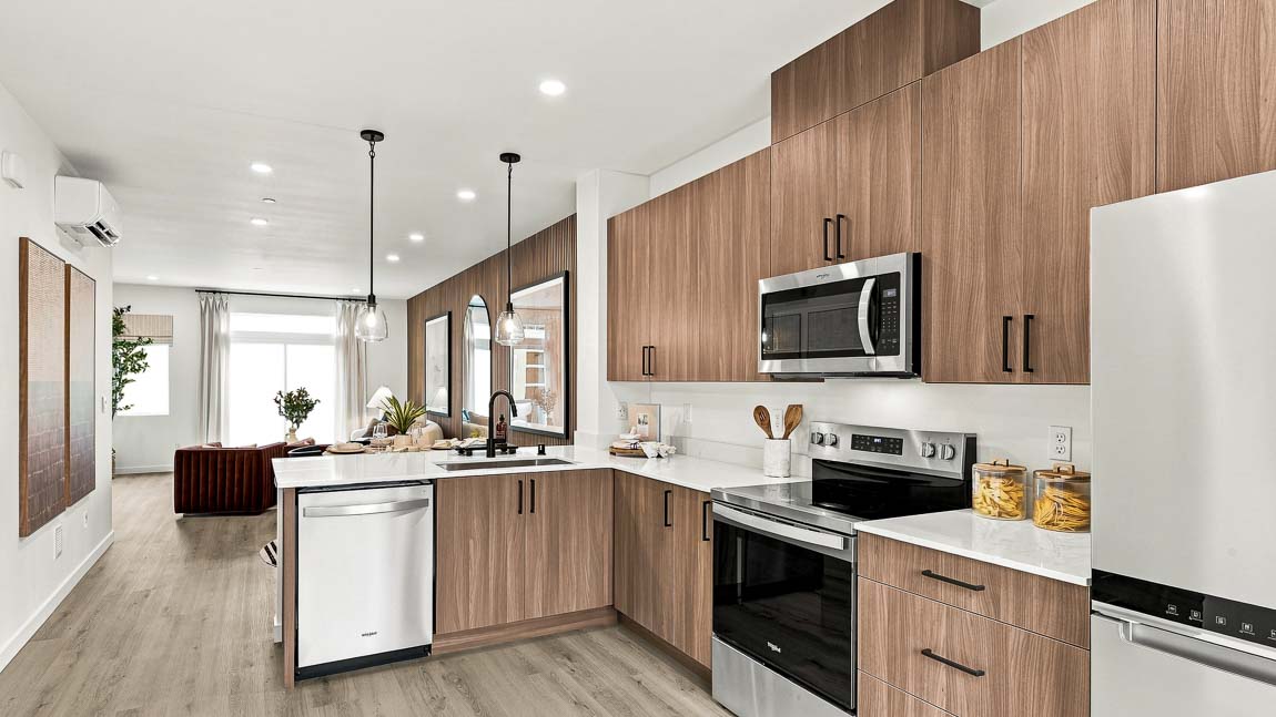 Bright kitchen featuring stainless steel refrigerator, electric range, microwave, and large window for natural light.