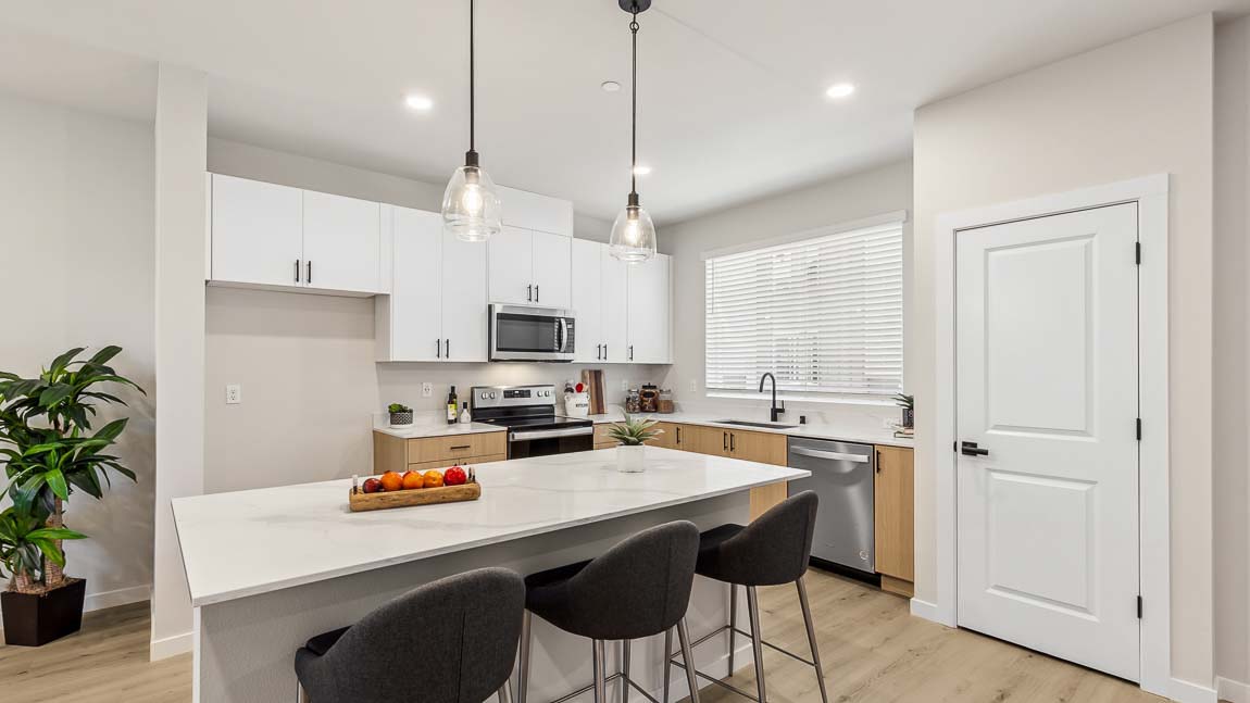 View of spacious kitchen island with pendent lighting