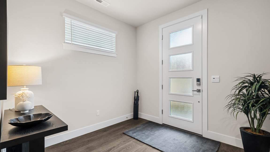 Entryway foyer and hallway view leading to fifth bedroom kitchen and main floor bathroom