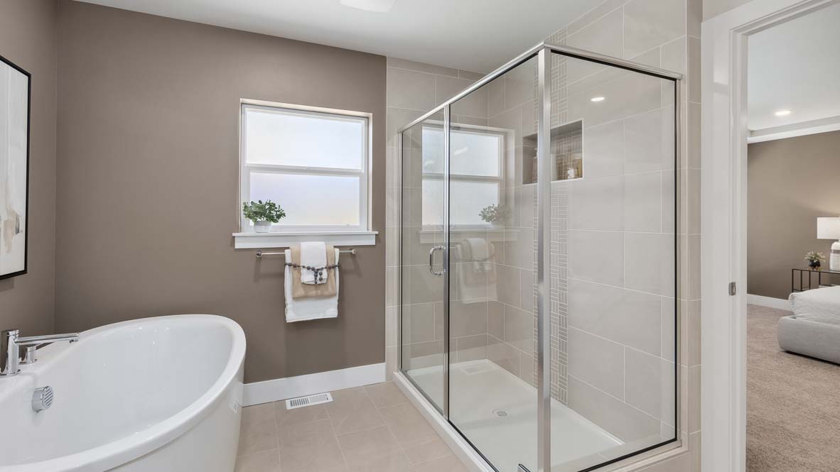 Step-in shower with glass front, full height ceramic tile and built-in wall cubby