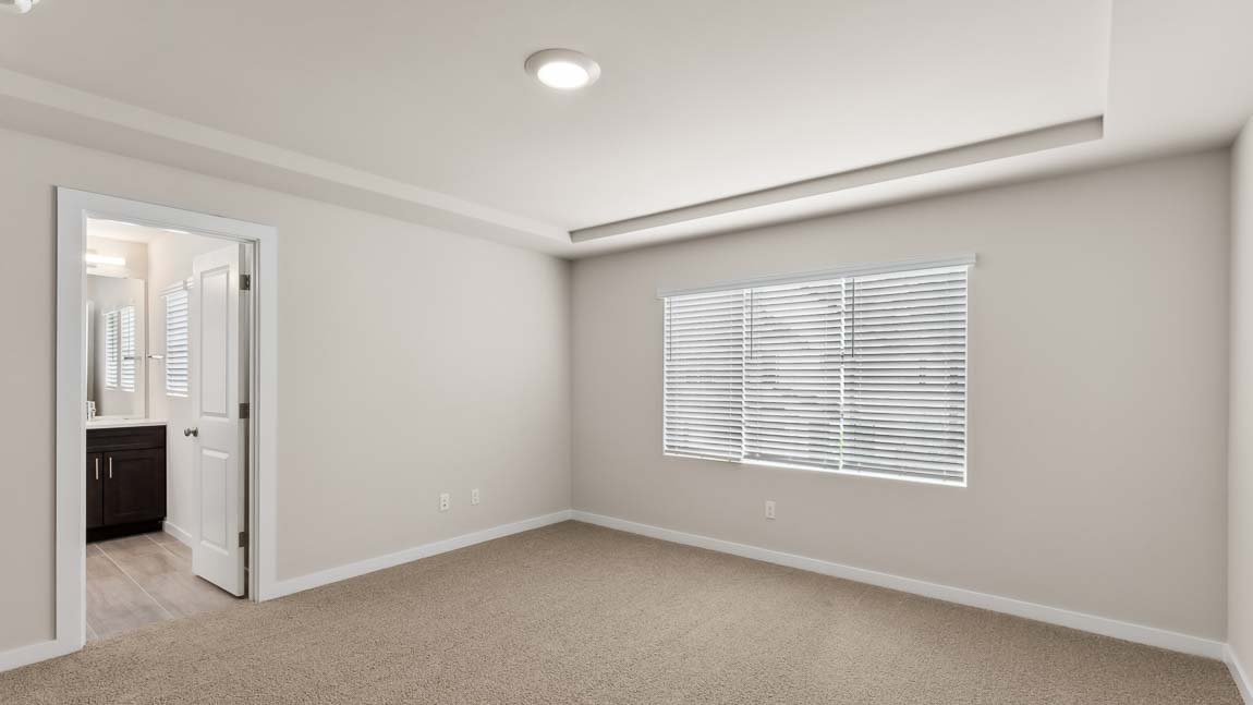 Alternate view of primary bedroom with peak into en-suite bathroom