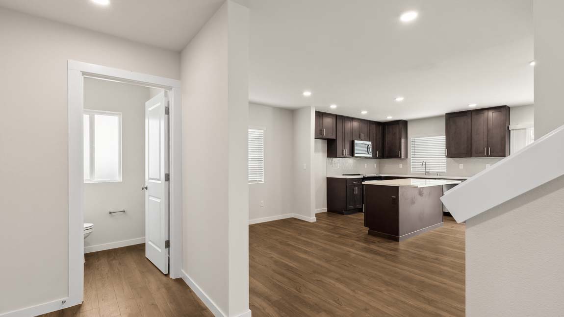 View into Main floor powder room and open concept kitchen and great room