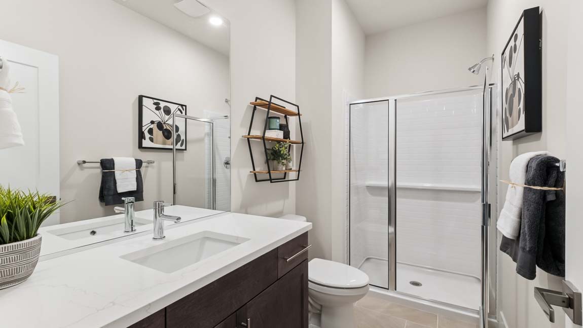 Main floor bathroom with shower and chrome fixtures and tile backsplash