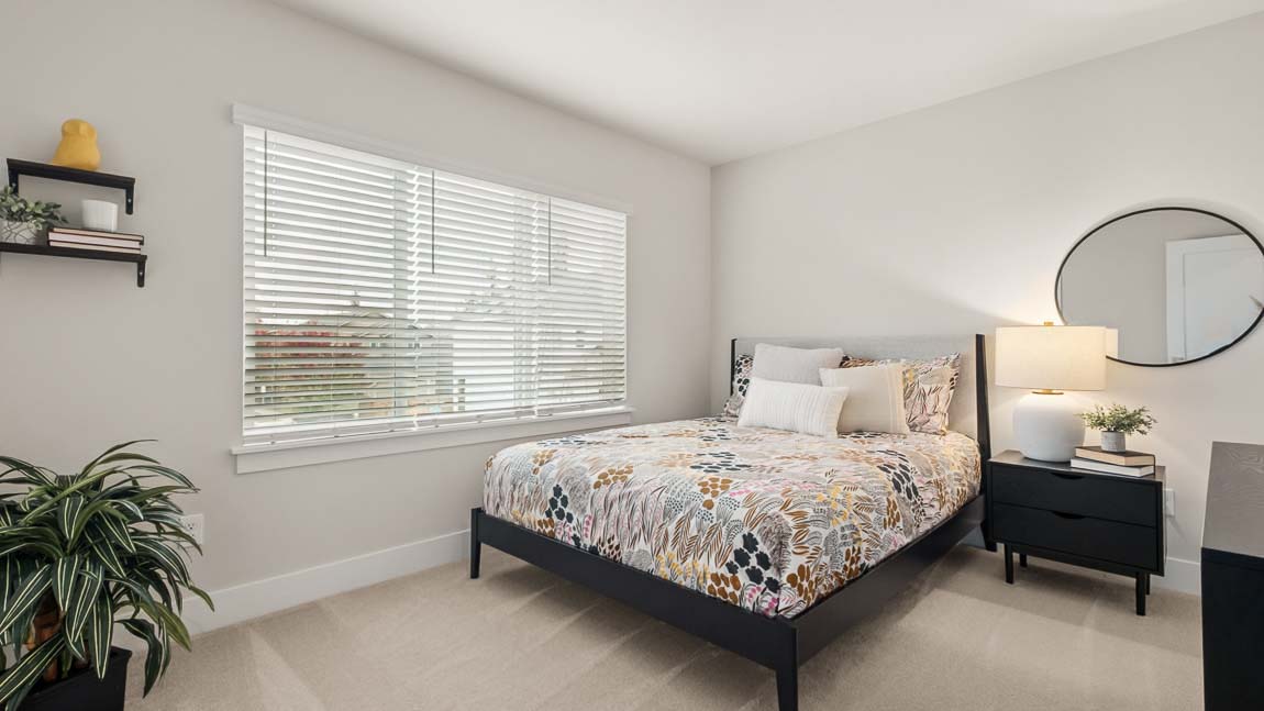 Secondary bedroom on upper floor with plush carpeting between third bedroom and primary bedroom