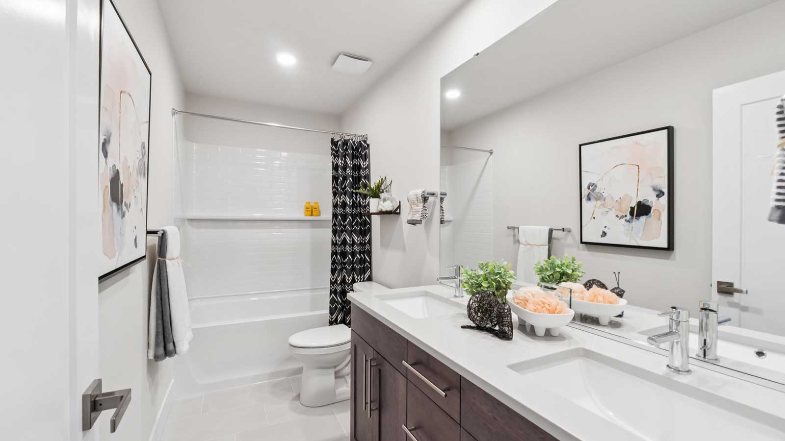 Upper-level hallway bathroom with shower and tub combo and 2 sink vanity