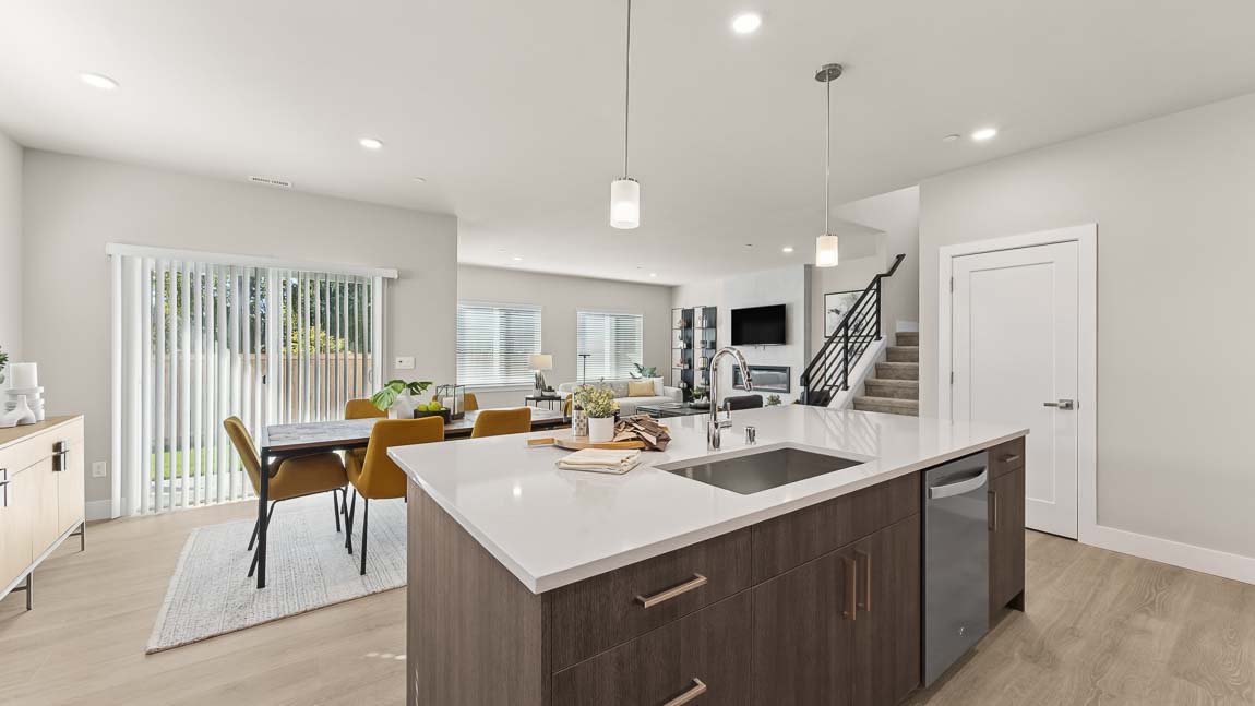 View of kitchen island looking out into dining and living area spaces