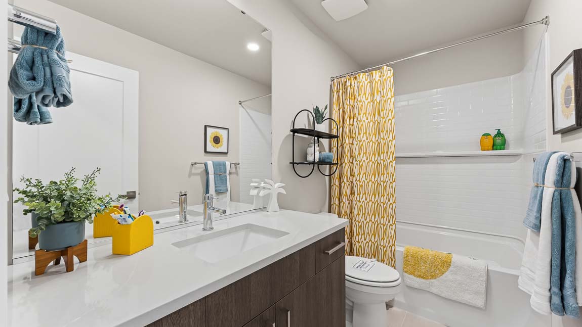 Upper floor secondary bathroom with shower tub combo chrome fixtures large mirror and tile backsplash