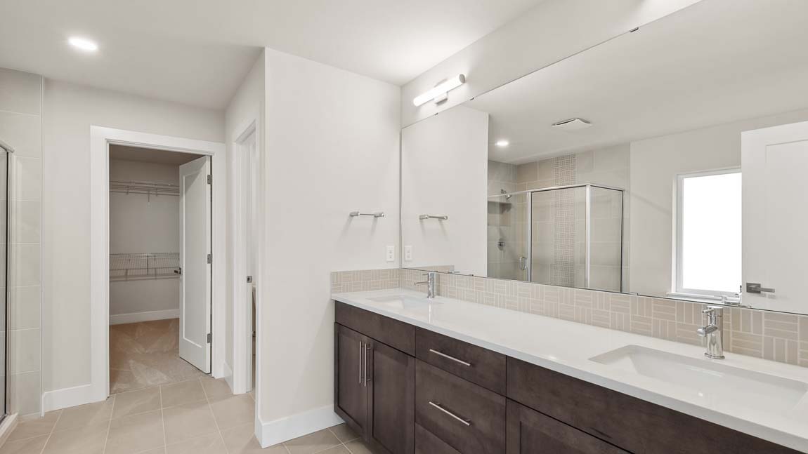 Primary bathroom with peak at walk-in closet