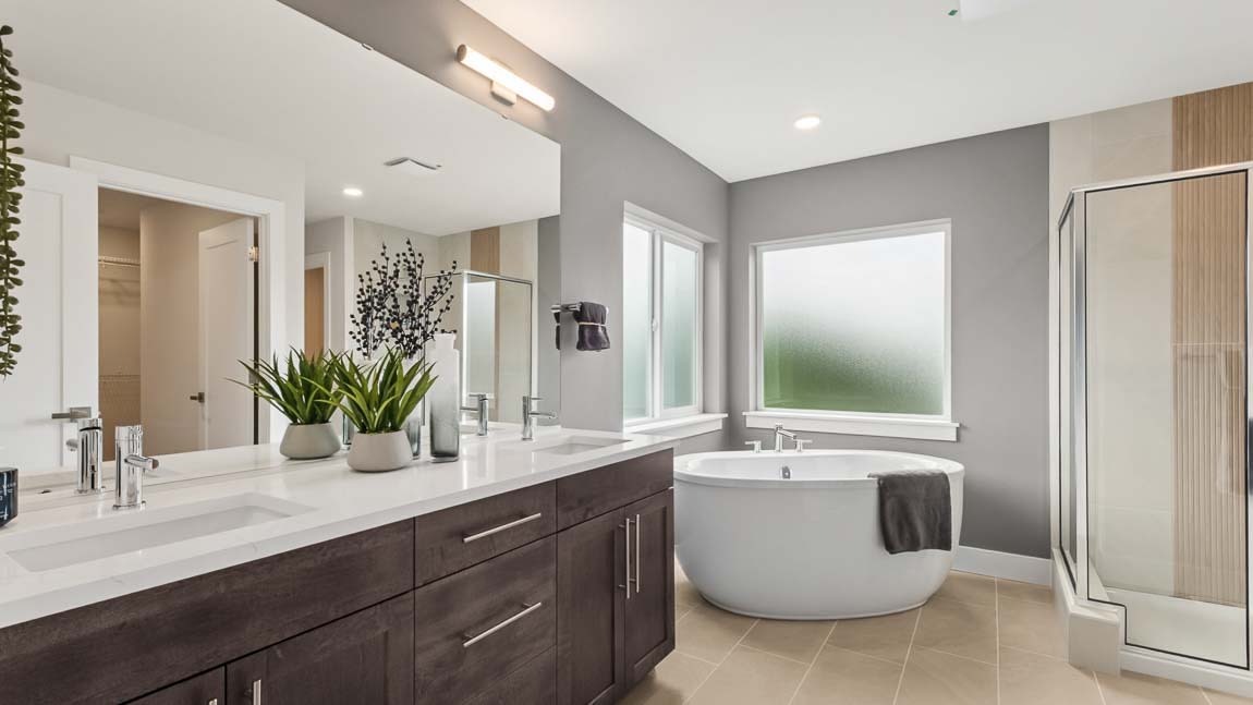 Primary bathroom showcasing 2 sink vanity and soaking tub
