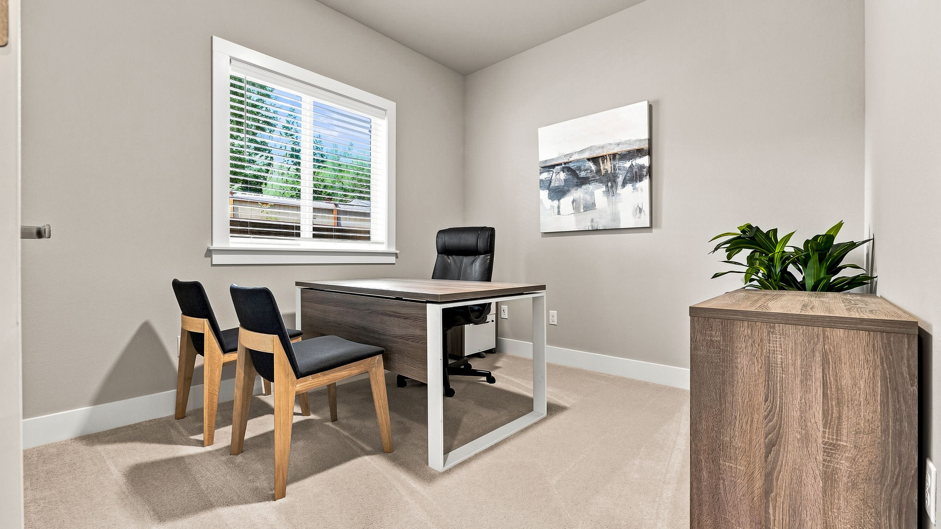 Home office with desk, executive chair, two guest chairs, window, and storage cabinet.