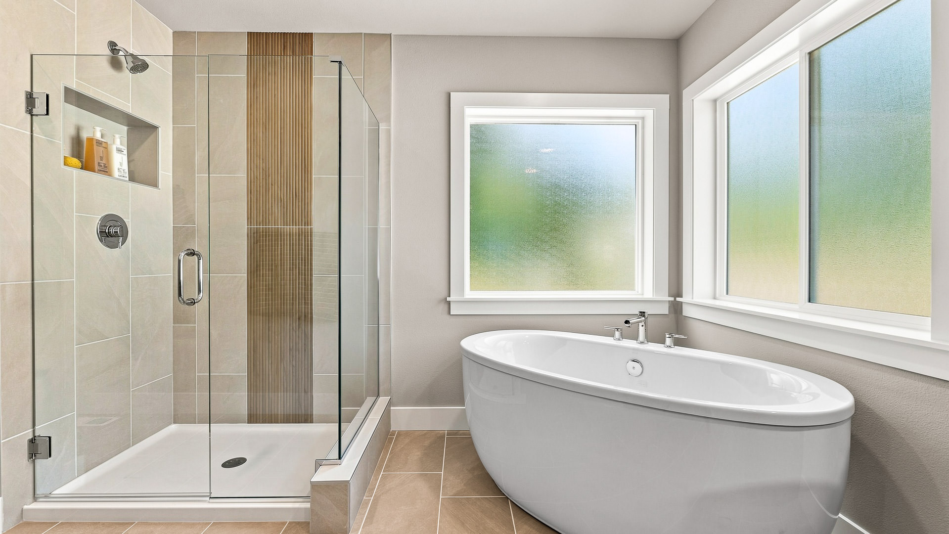 Spa-inspired bathroom with freestanding soaking tub beside frosted windows and walk-in shower.
