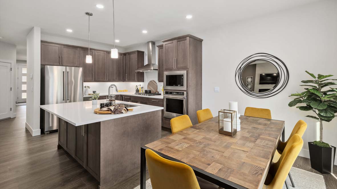 Spacious kitchen and dining room with oversized island, wood cabinetry, and seating for six.