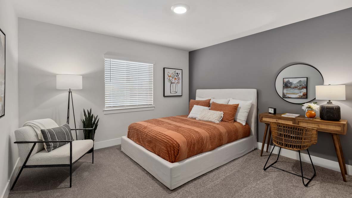 Guest bedroom with upholstered bed, accent wall, writing desk, and contemporary furnishings.