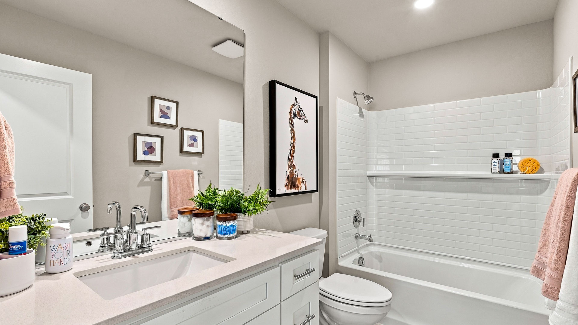 Walk-in closet with white wire shelving and hanging rods, shown with two white robes, several hangers, and hats.