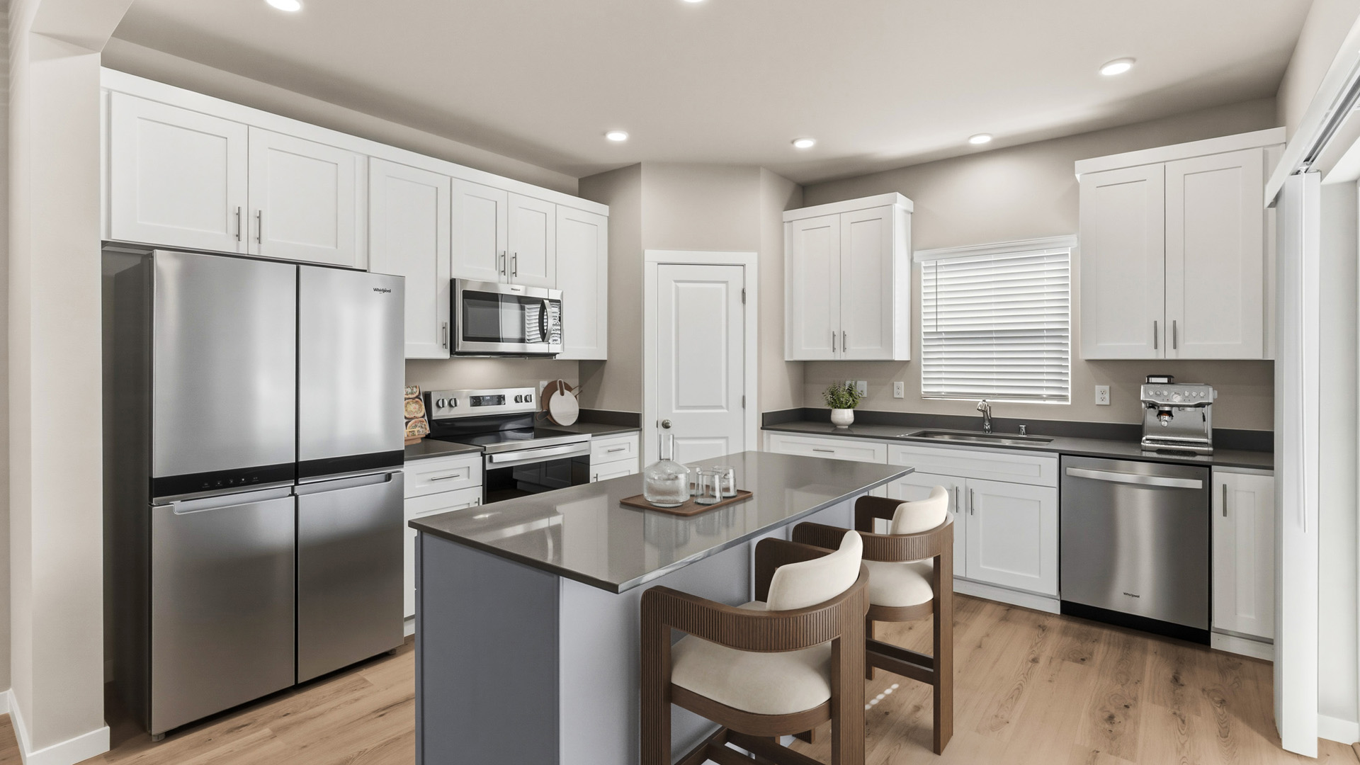 Modern kitchen with white cabinets, stainless steel appliances, a gray island, two upholstered counter stools, and light wood flooring.