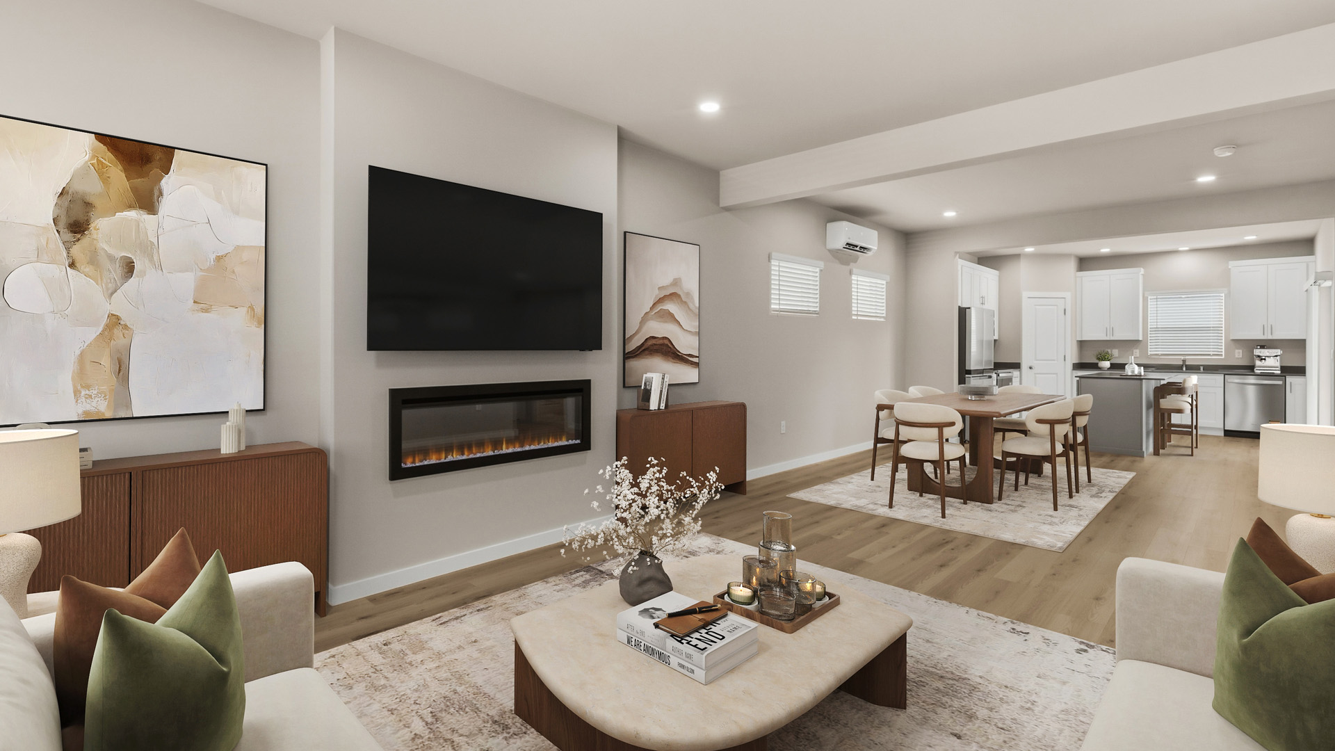 Open living room with cream seating, green and brown accent pillows, a rounded coffee table, wall-mounted TV, linear fireplace, and dining area beyond.