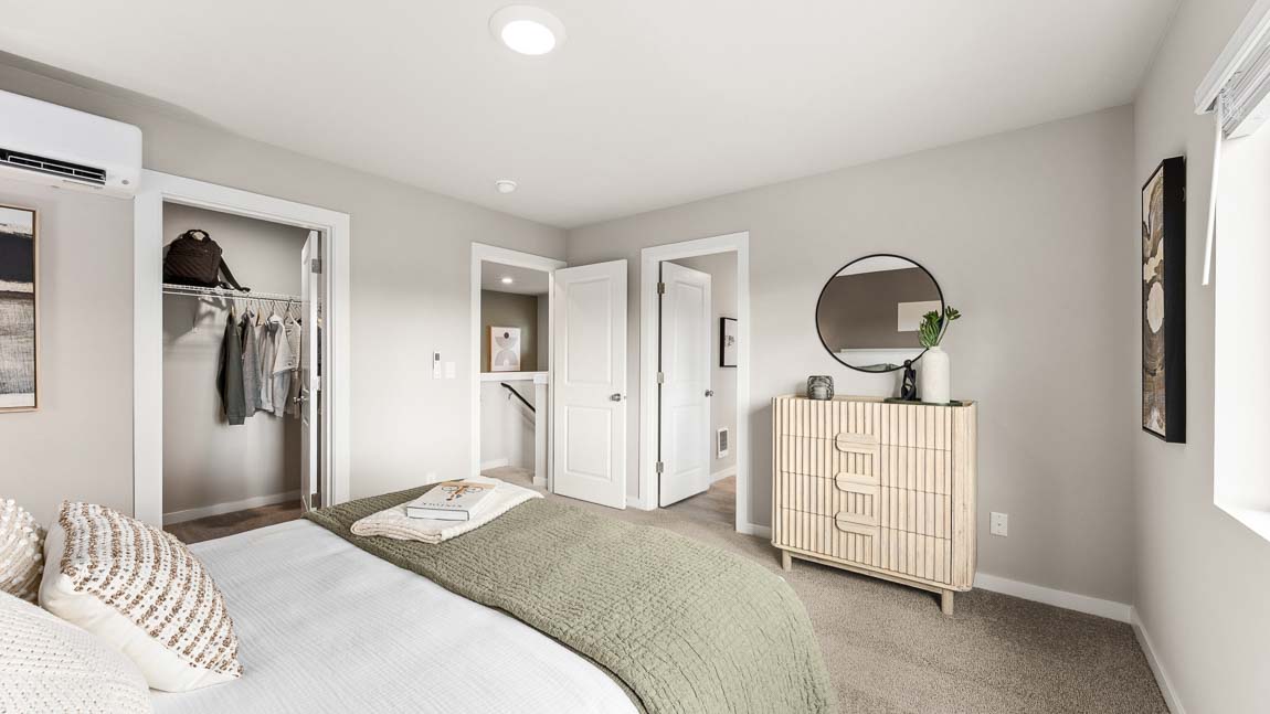 Alternate view of primary bedroom suite with view into the en-suite bathroom and large walk-in closet.