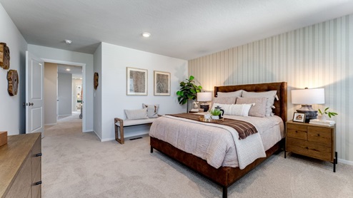 Primary bedroom with wall-to-wall carpet, a walk-in closet and an attached bathroom