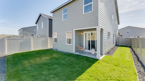 backyard with sod and vinyl plank fence and covered patio