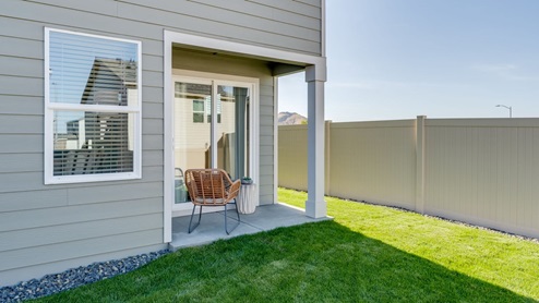 backyard with sod and vinyl plank fence and covered patio